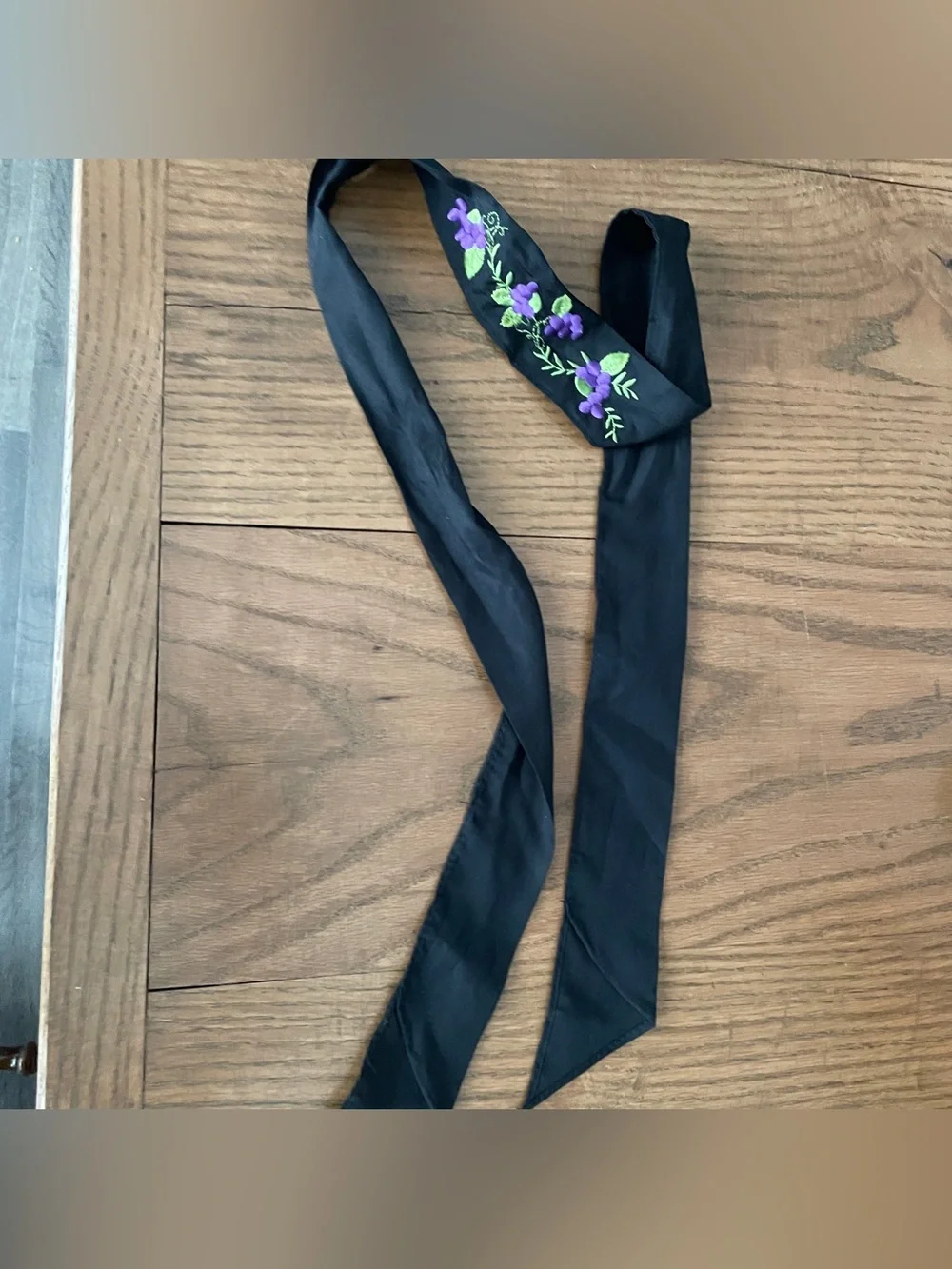 Black cloth hair scarf with purple floral embroidery and green leaves